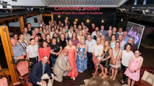 Large group of Albury Wodonga business community members gathered at an evening event, with Community Matters text overlayed above them.